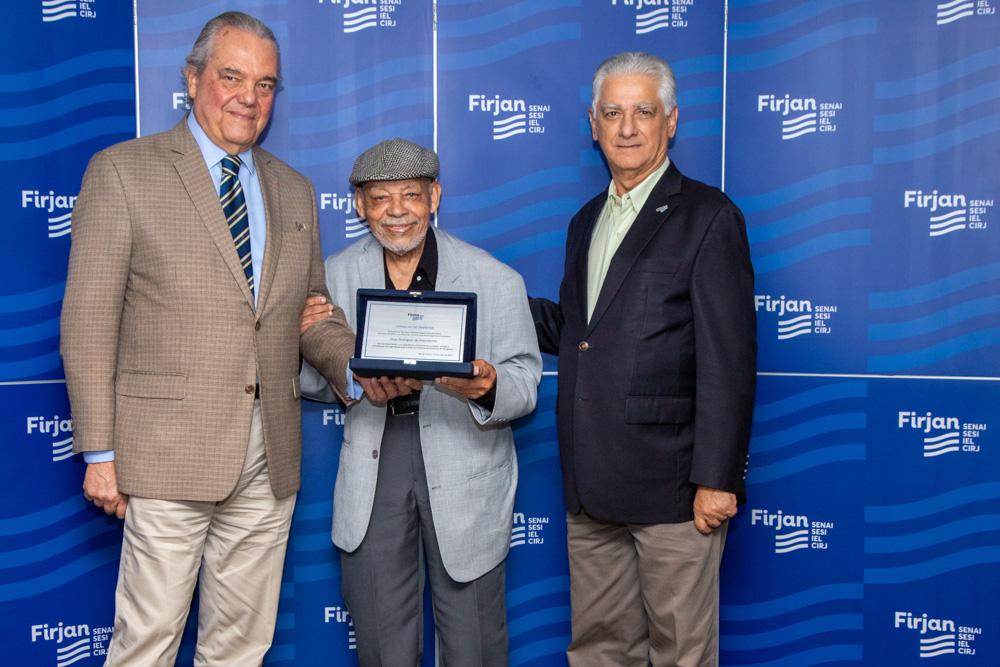 Jorge Rodrigues do Nascimento recebe homenagem de Eduardo Eugenio e Luiz Césio Caetano no dia 10/07/2023. Créditos: Paula Johas/ Acervo Firjan